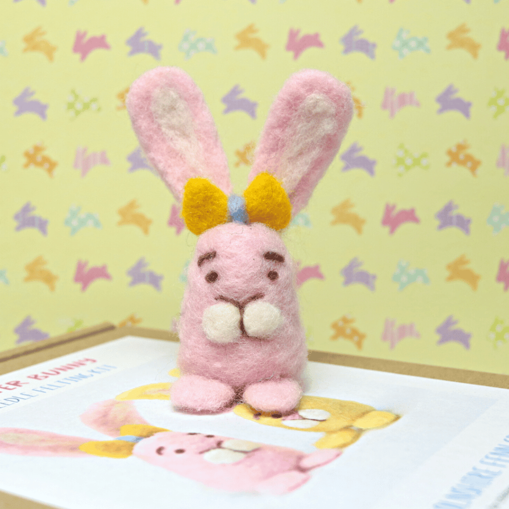 needle felted easter bunny with a seasonal bunny wallpaper background